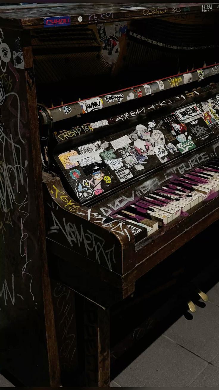 Sticker-covered upright piano with graffiti art